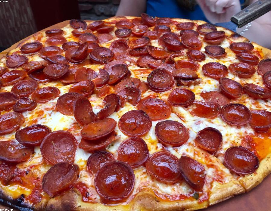 Teglia di pizza tagliata al peso e incartata per l'asporto
